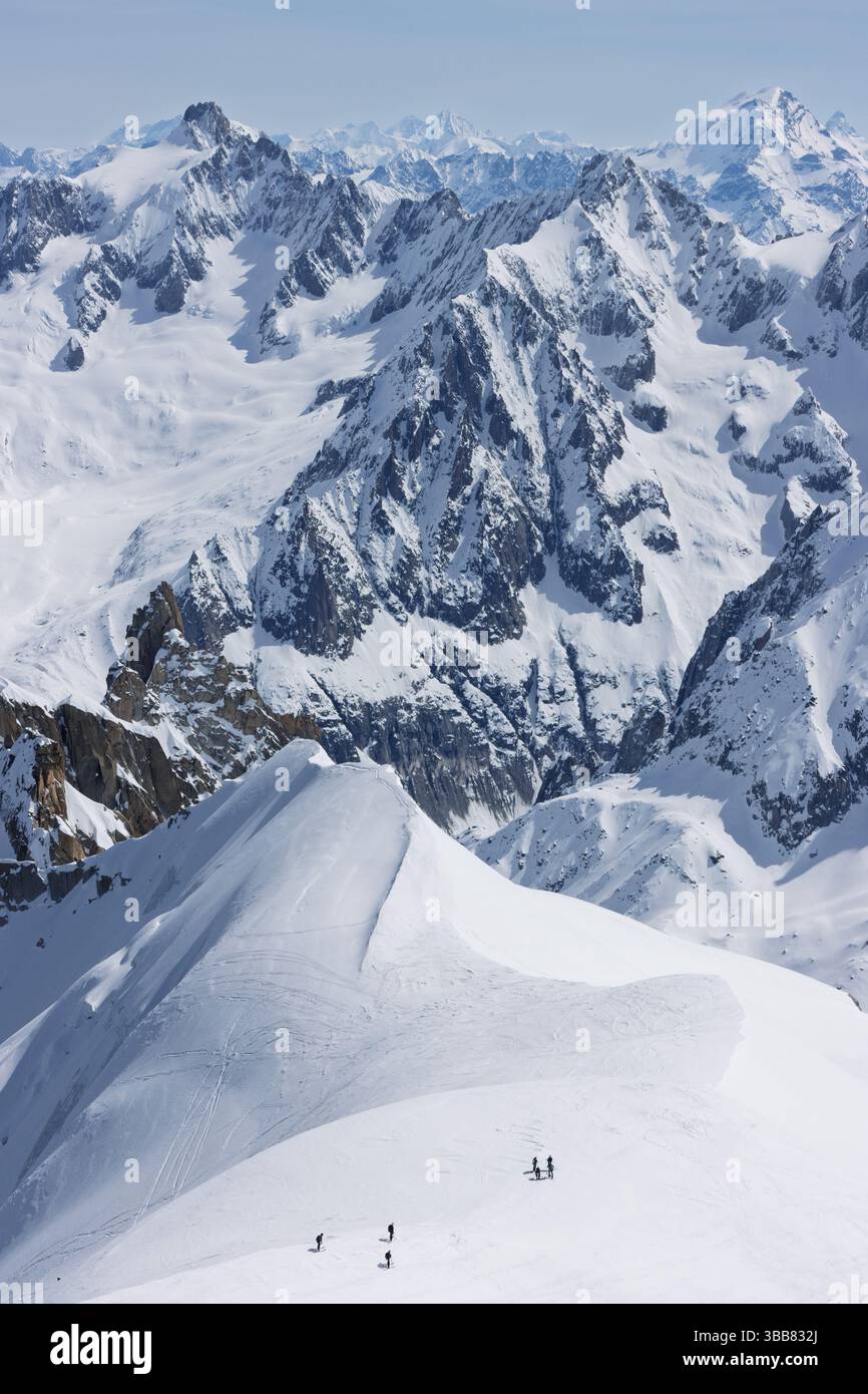 Scialpinisti su una splendida cresta vicino a Aigulle du Midi nel massiccio del Monte bianco nelle alpi francesi sopra Chamonix, con uno scenario montano spettacolare. Foto Stock