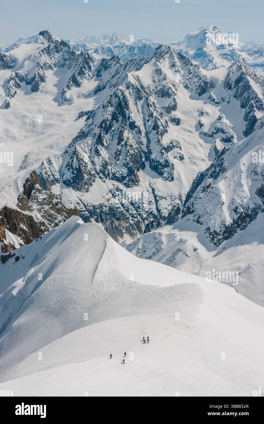 Scialpinisti su una splendida cresta vicino a Aigulle du Midi nel massiccio del Monte bianco nelle alpi francesi sopra Chamonix, con uno scenario montano spettacolare. Foto Stock