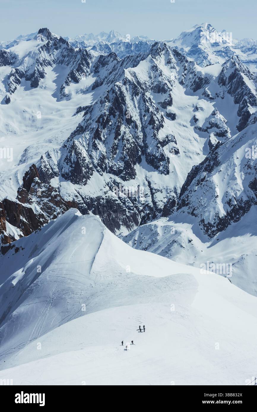 Scialpinisti su una splendida cresta vicino a Aigulle du Midi nel massiccio del Monte bianco nelle alpi francesi sopra Chamonix, con uno scenario montano spettacolare. Foto Stock