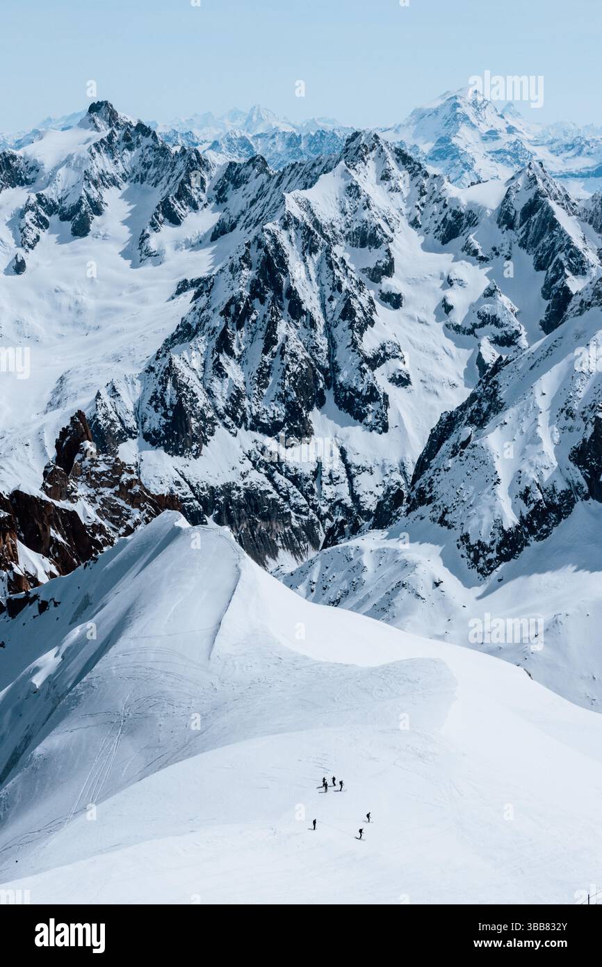 Scialpinisti su una splendida cresta vicino a Aigulle du Midi nel massiccio del Monte bianco nelle alpi francesi sopra Chamonix, con uno scenario montano spettacolare. Foto Stock