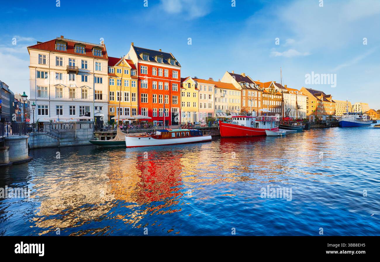 Edificio di colore Copenhagen a Nyhavn con cielo e sole blu, Danimarca Foto Stock