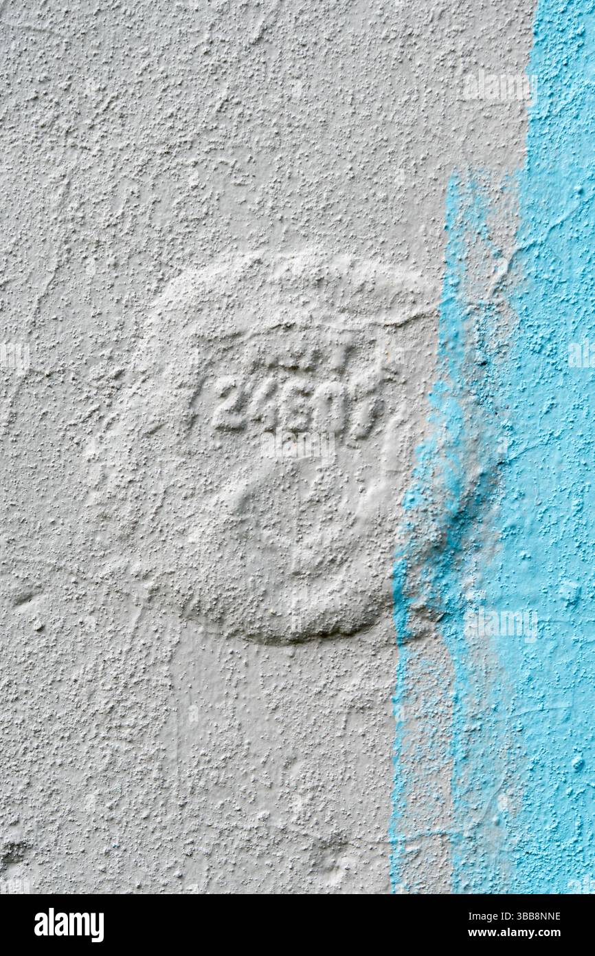 Sfondo con intonaco bianco con pennellate blu e un timbro con numeri. Foto di alta qualità Foto Stock