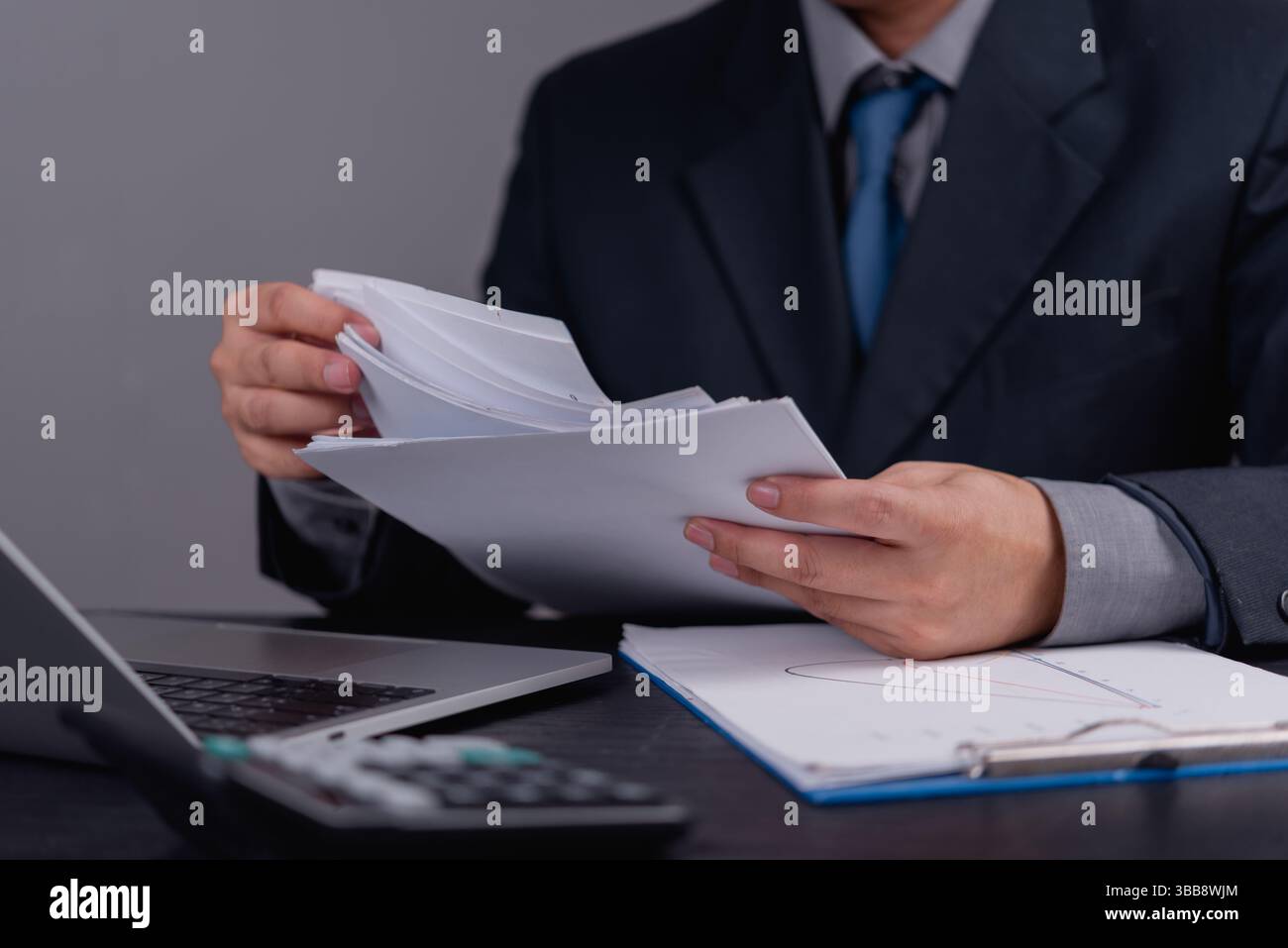 Il dirigente d'azienda controlla i dati finanziari e i documenti ufficiali. Analisi aziendale, pianificazione finanziaria, gestione, calcolo fiscale e professionale Foto Stock