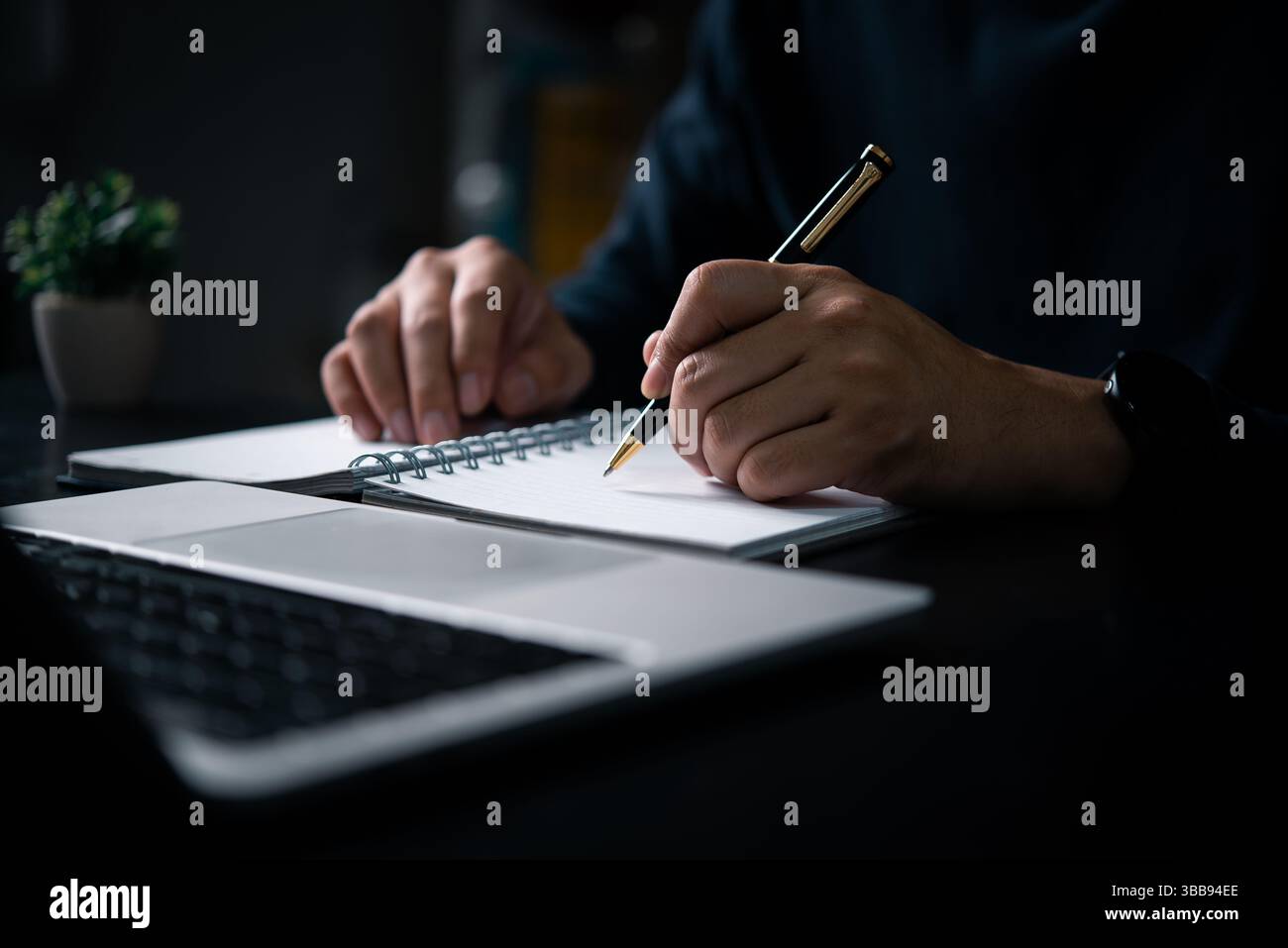 un uomo d'affari scrive appunti su un notebook con un portatile sulla scrivania. Il concetto di pianificazione, istruzione e lavoro a distanza. strategia aziendale, definizione degli obiettivi Foto Stock