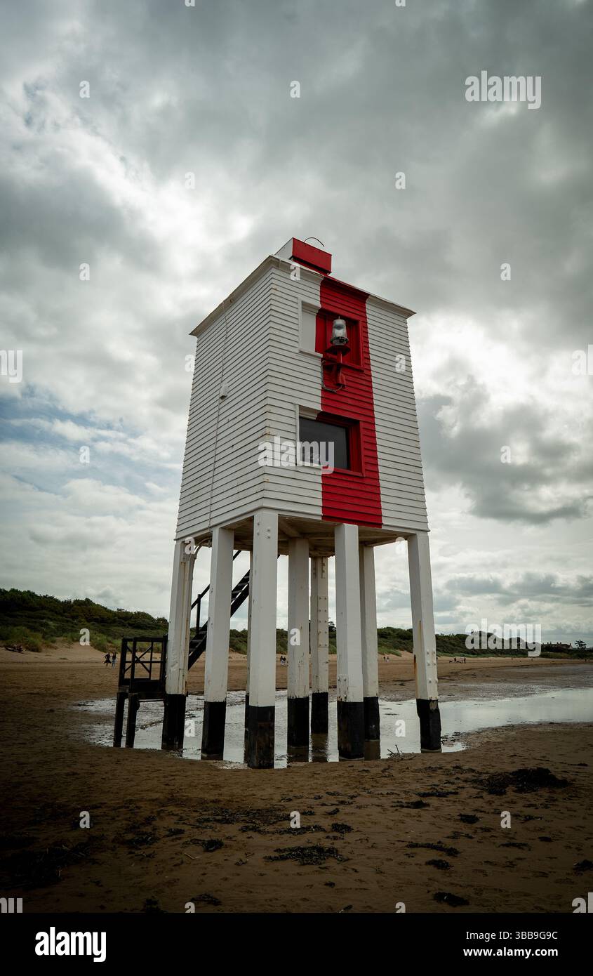 L'iconico faro di Burnham-on-Sea si erge alto contro un cielo lunare, un faro di storia sulla spiaggia sabbiosa. Foto Stock
