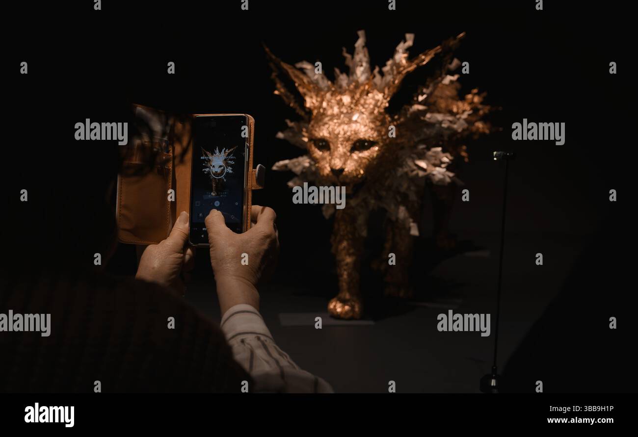 Jolteon dorato sotto i riflettori, catturato attraverso la lente di un visitatore alla mostra Pokémon x Kogei Foto Stock