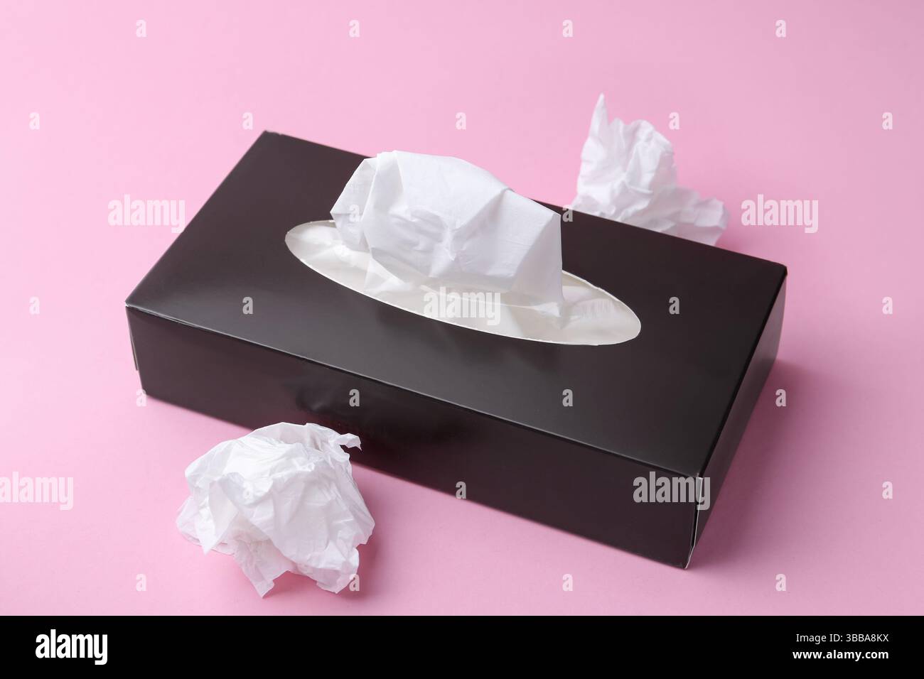 Scatola con fazzoletti di carta e fazzoletti su sfondo rosa, primo piano Foto Stock