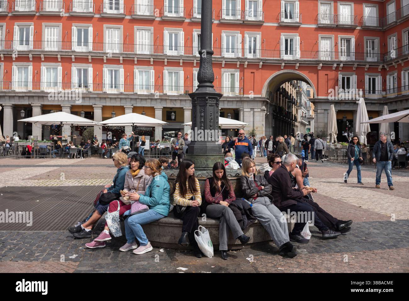 I turisti sedevano in Plaza Mayor, la piazza principale nel cuore della vecchia Madrid, Spagna Foto Stock