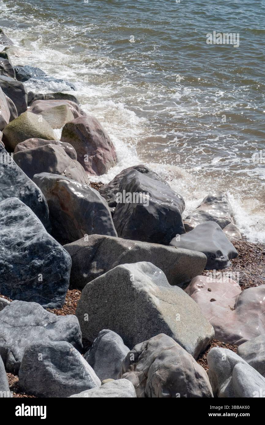 Rocce levigate dal battito dell'oceano sulla spiaggia di Sidmouth, Devon, Regno Unito Foto Stock