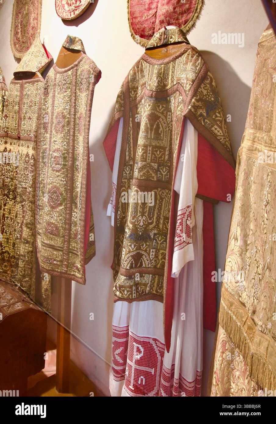 Collezione di casuli indossati dai sacerdoti per la messa in una vetrina nella iglesia de San Martín Plaza Mayor Trujillo Caceres Extremadura Spagna Europa Foto Stock