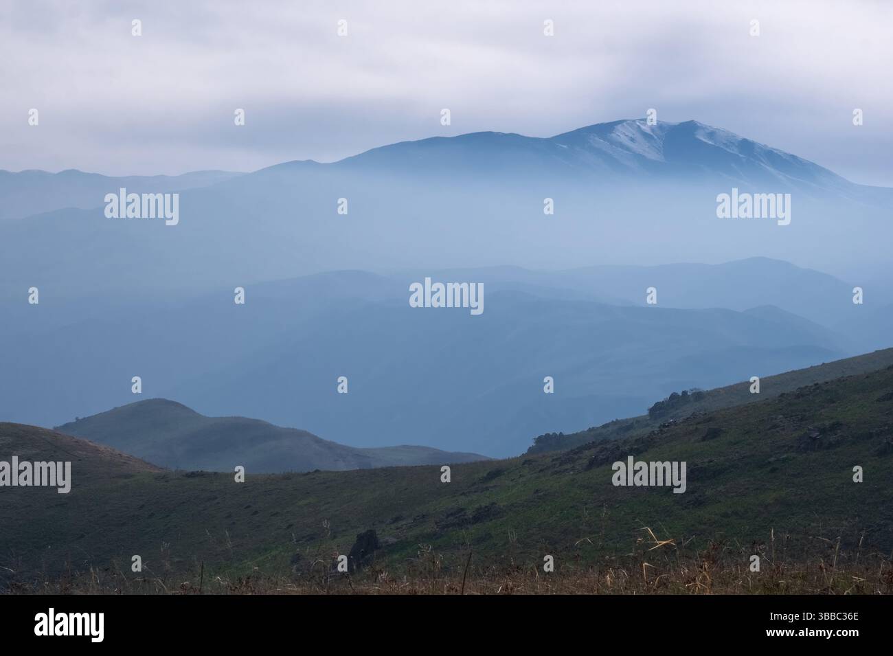 Montagne in una foschia blu nebbiosa in una serata primaverile. Un paesaggio tranquillo nello stile di Roerich. Foto Stock