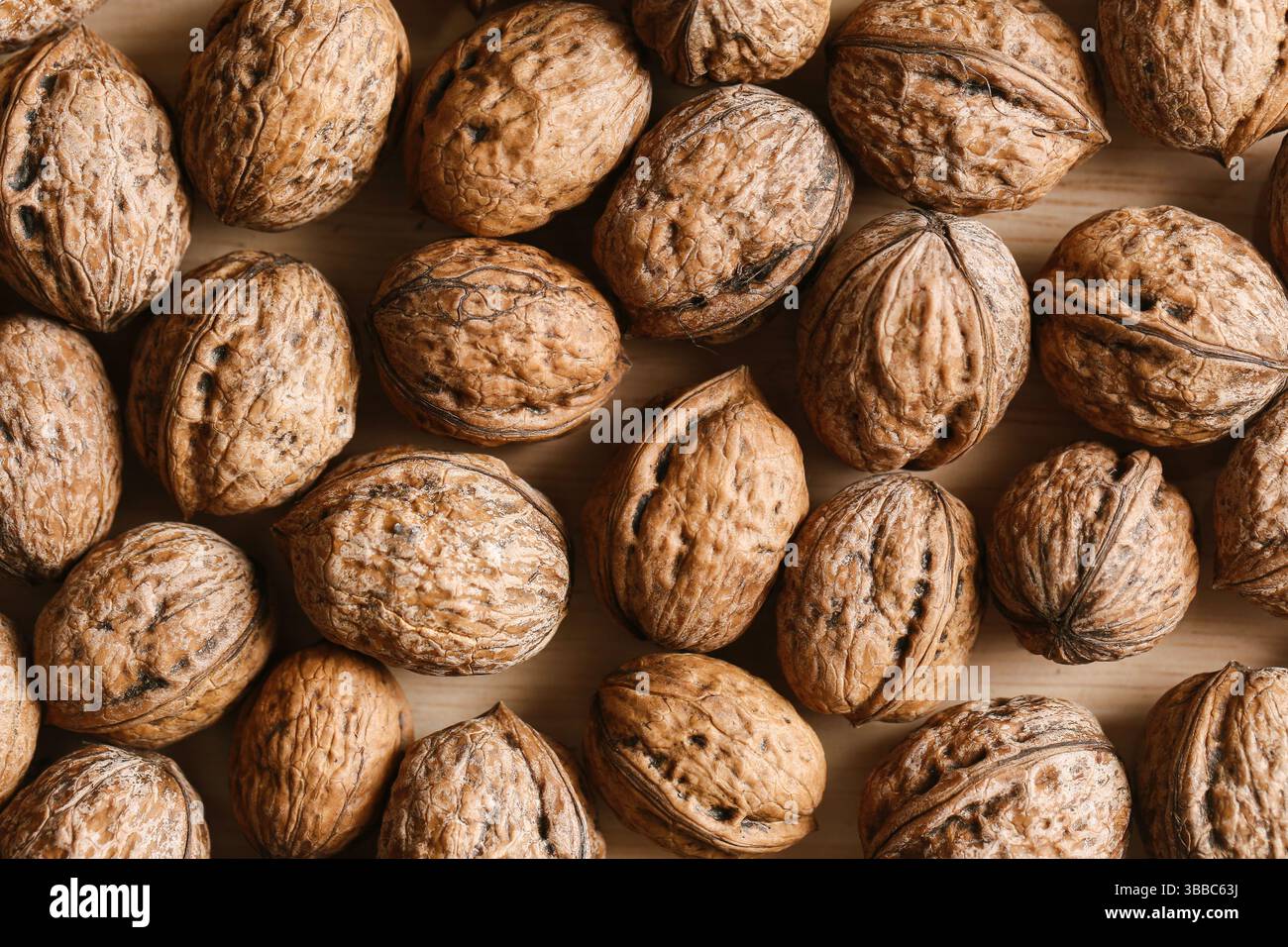 Vista dall'alto delle noci marroni. Fondo naturale di frutta a guscio. Spuntino sano biologico. Primo piano della trama del guscio asciutto. Ingrediente alimentare nutriente. Raccolto autunnale Foto Stock