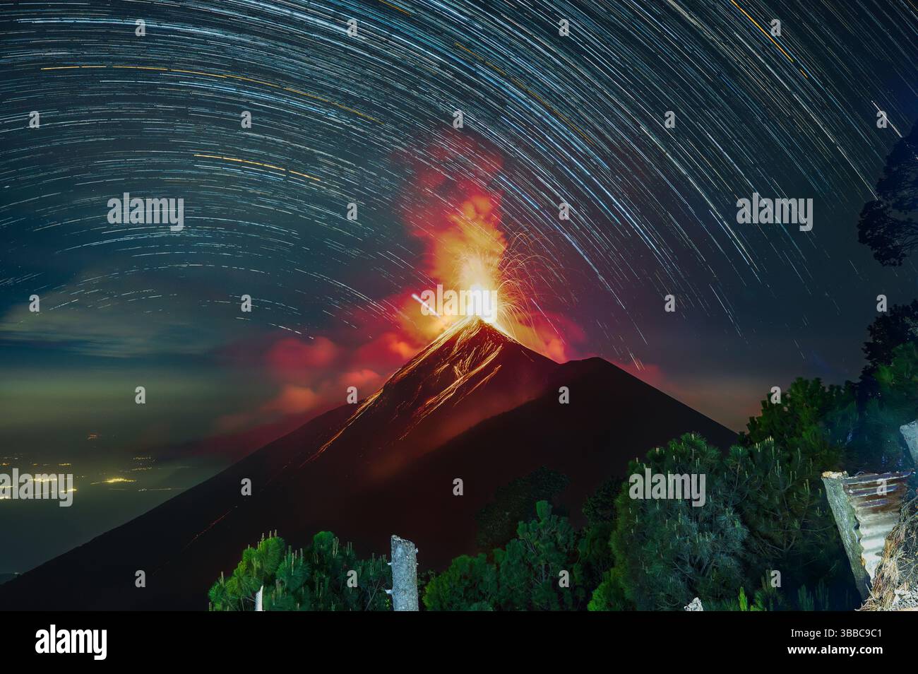 Lunga esposizione composita che mostra sentieri stellari sopra l'eruzione del Volcan de Fuego vicino ad Antigua Guatemala, catturati da Acatenango durante un'escursione Expedi Foto Stock