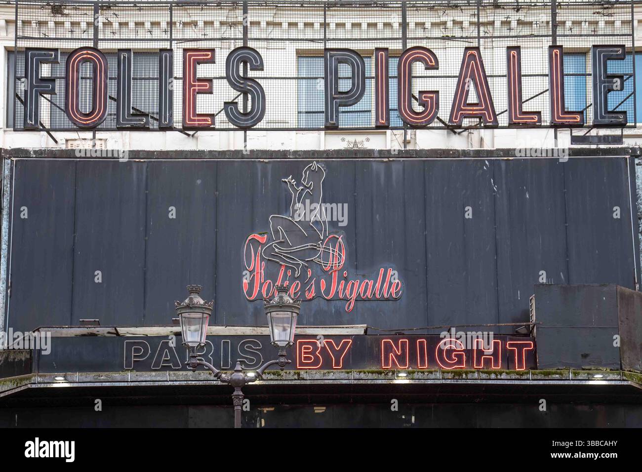 Folies Pigalle, Parigi di notte. Segnaposto al neon, in parte lavorato, sulla facciata grungy dell'iconico night club nel quartiere Montmartre di Parigi, Francia. Foto Stock