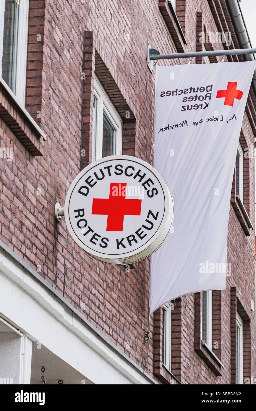 Segno rotondo della Croce Rossa tedesca e uno striscione su un lato di un edificio Foto Stock