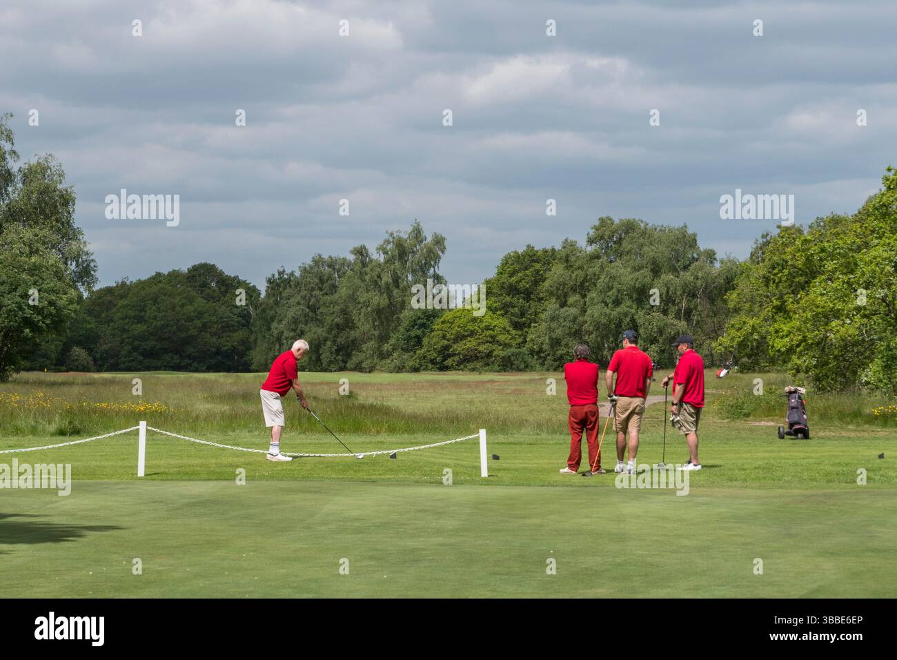 I golfisti, tutti vestiti di rosso, giocano al Wimbledon Common Golf Club, Wimbledon, Londra, Regno Unito. Foto Stock
