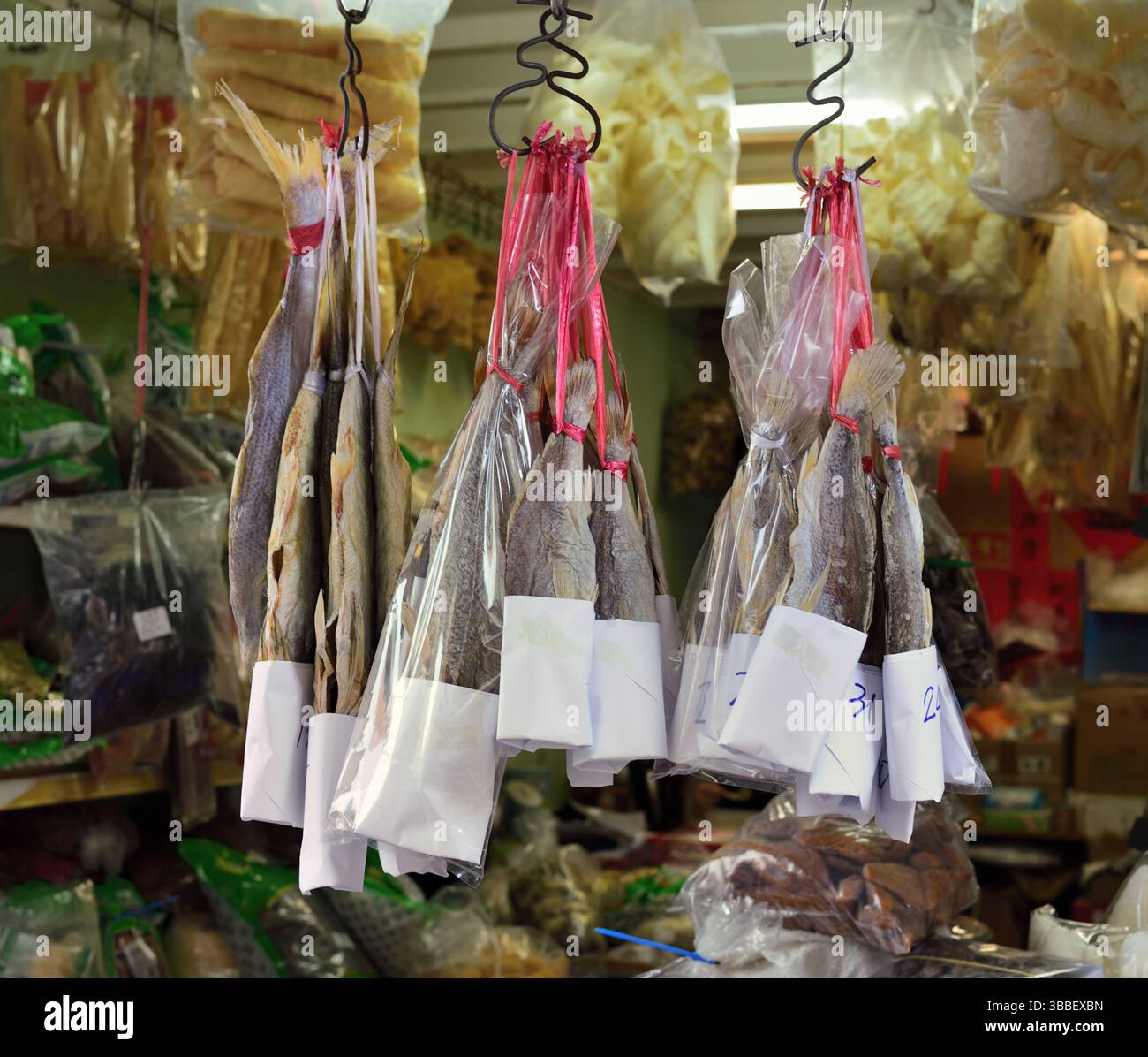 Il pesce salato è appeso su ganci di ferro all'interno di un negozio di alimentari, Cheung Chau, Hong Kong Foto Stock