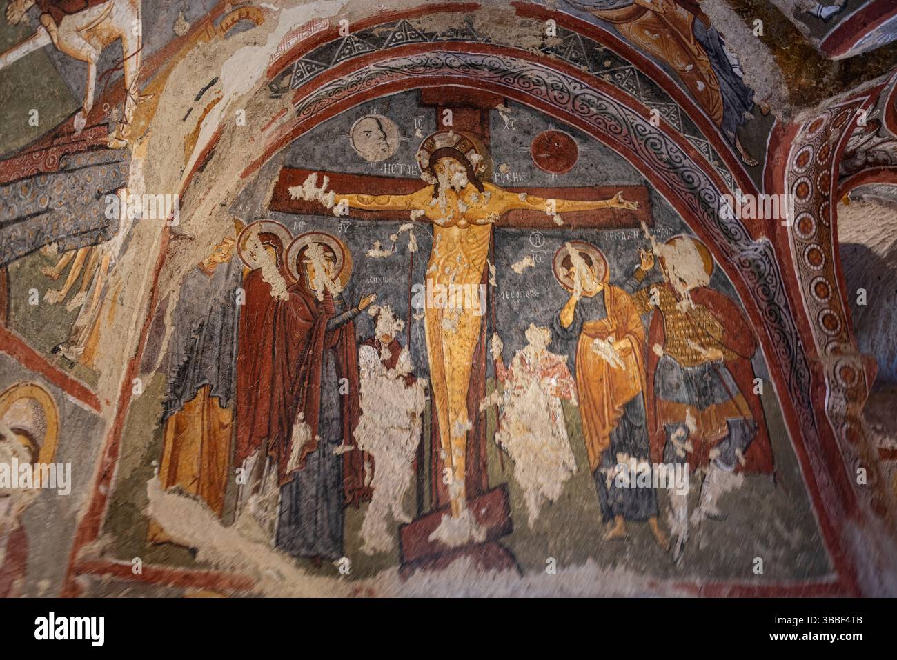 Nella Chiesa Carikli, Goreme, un affresco della Crocifissione di Gesù copre l'abside, illustrando il dramma biblico con figure espressive e colori. Foto Stock