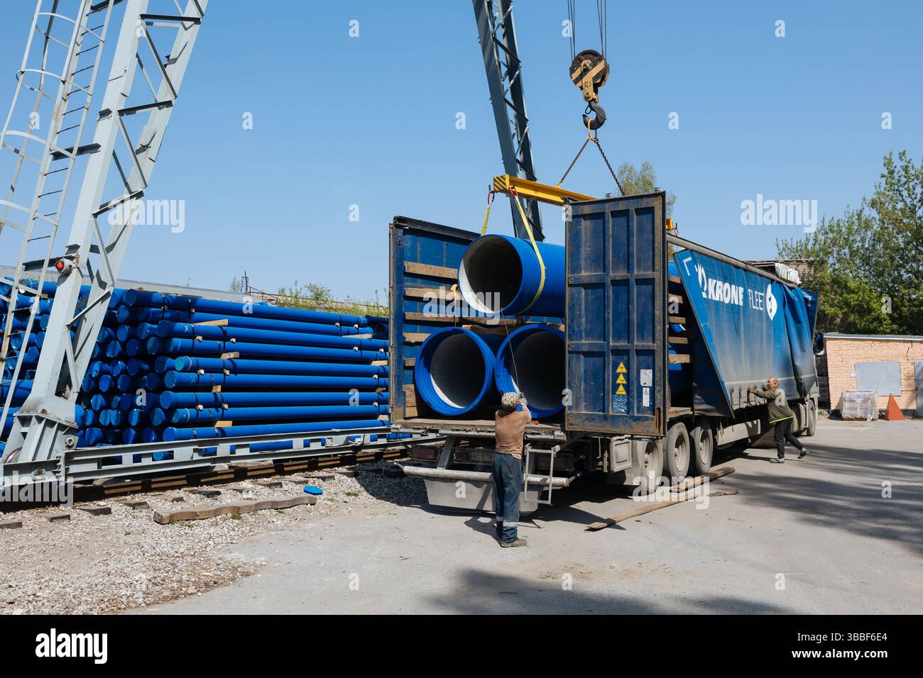 Caricamento del tubo in ghisa nel camion per il trasporto con carroponte. Foto Stock