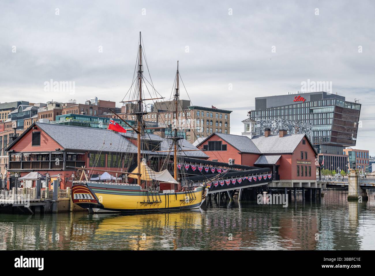 Il museo del tè di Boston e la replica della nave Beaver nel porto/porto di Boston sul lungomare, si affacciano sullo skyline e sull'architettura storica e moderna Foto Stock