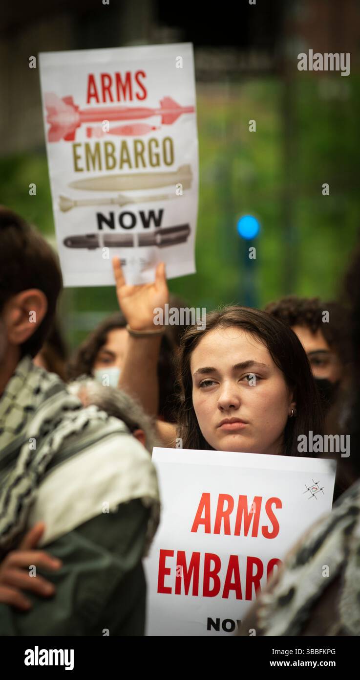 Nakba Day, Cambridge, Massachusetts, 15 maggio 2025. Da 50 a 100 manifestanti pro-palestinesi si sono riuniti di fronte al Kendall/MIT T Stop vicino al Massachusetts Institute of Technology (MIT). Cambridge, accanto a Boston, è sede del MIT e delle università di Harvard. Una donna ha un cartello che chiede un embargo sulle armi contro Israele. La T è il nome del principale transito di massa nell'area di Boston. Crediti: Chuck Nacke / Alamy Live News Foto Stock