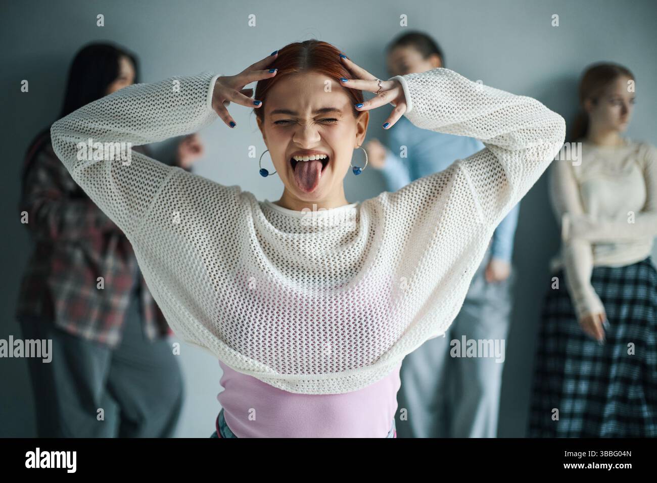 Giovane donna che si diverte e fa un gesto facciale divertente Foto Stock