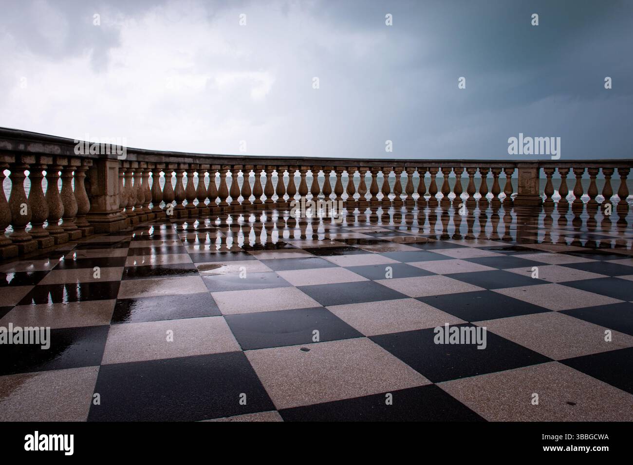 La Terrazza Mascagni di Livorno incanta con il suo elegante motivo a scacchiera affacciato sul mare, tra cielo e onde in un panorama mozzafiato. Foto Stock