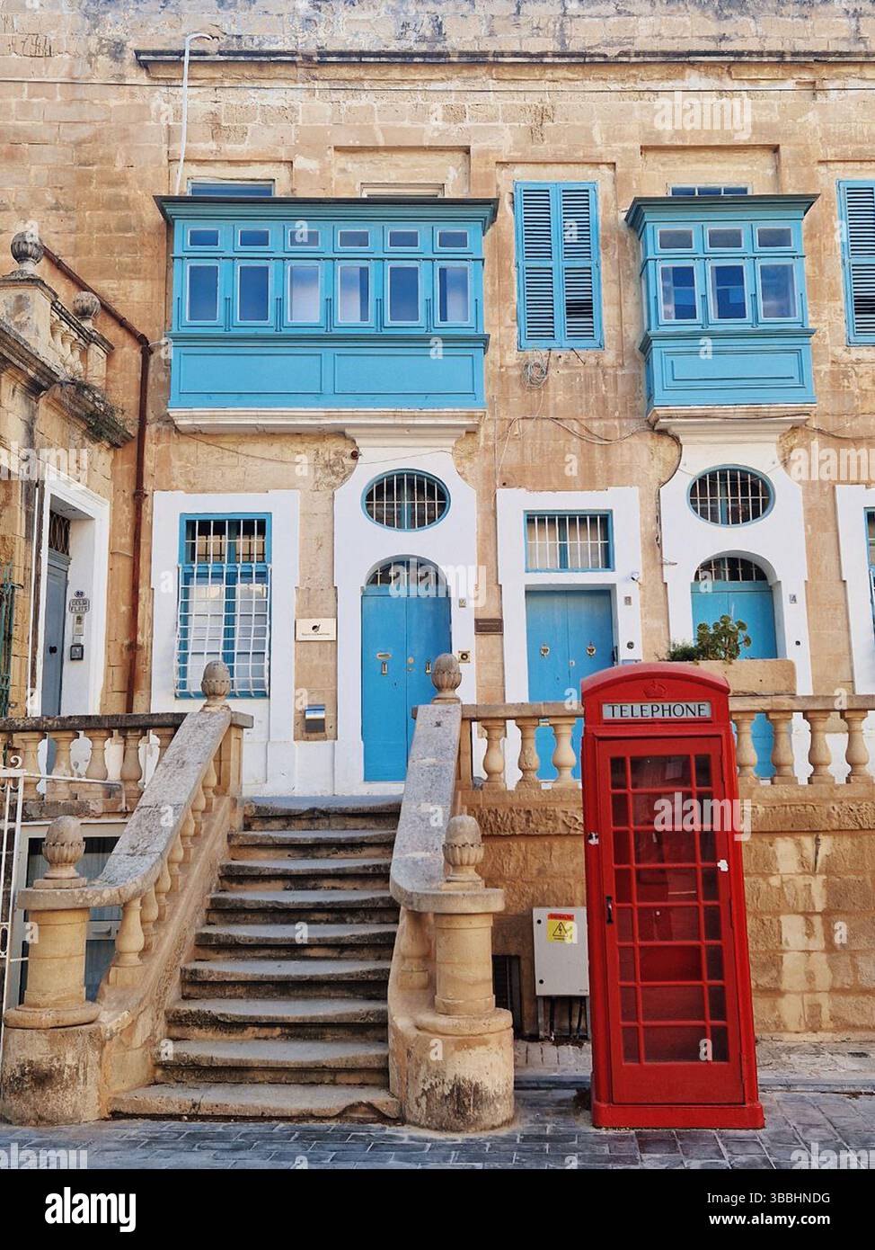 Architettura tradizionale in una città storica con una cabina telefonica rossa Foto Stock