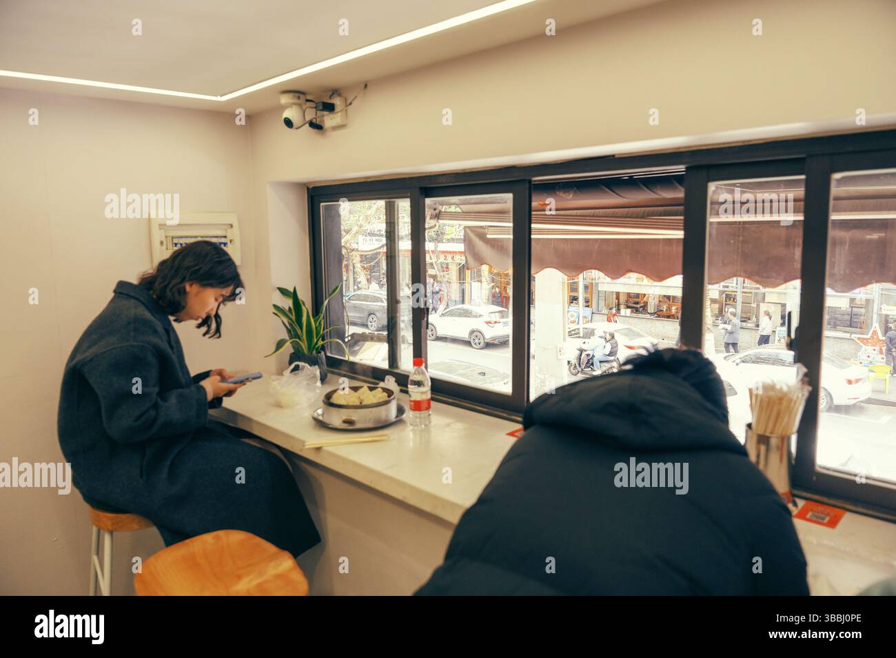 Banco finestra per pranzare presso un Changsha Street Dumpling Shop con vista su Urban Street Foto Stock