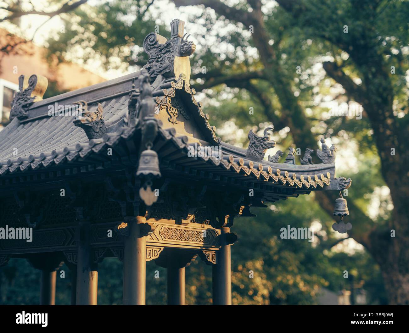 Tetto decorato in bronzo del padiglione con bestie e campane mitiche in un parco di Hangzhou, Zhejiang, Cina Foto Stock