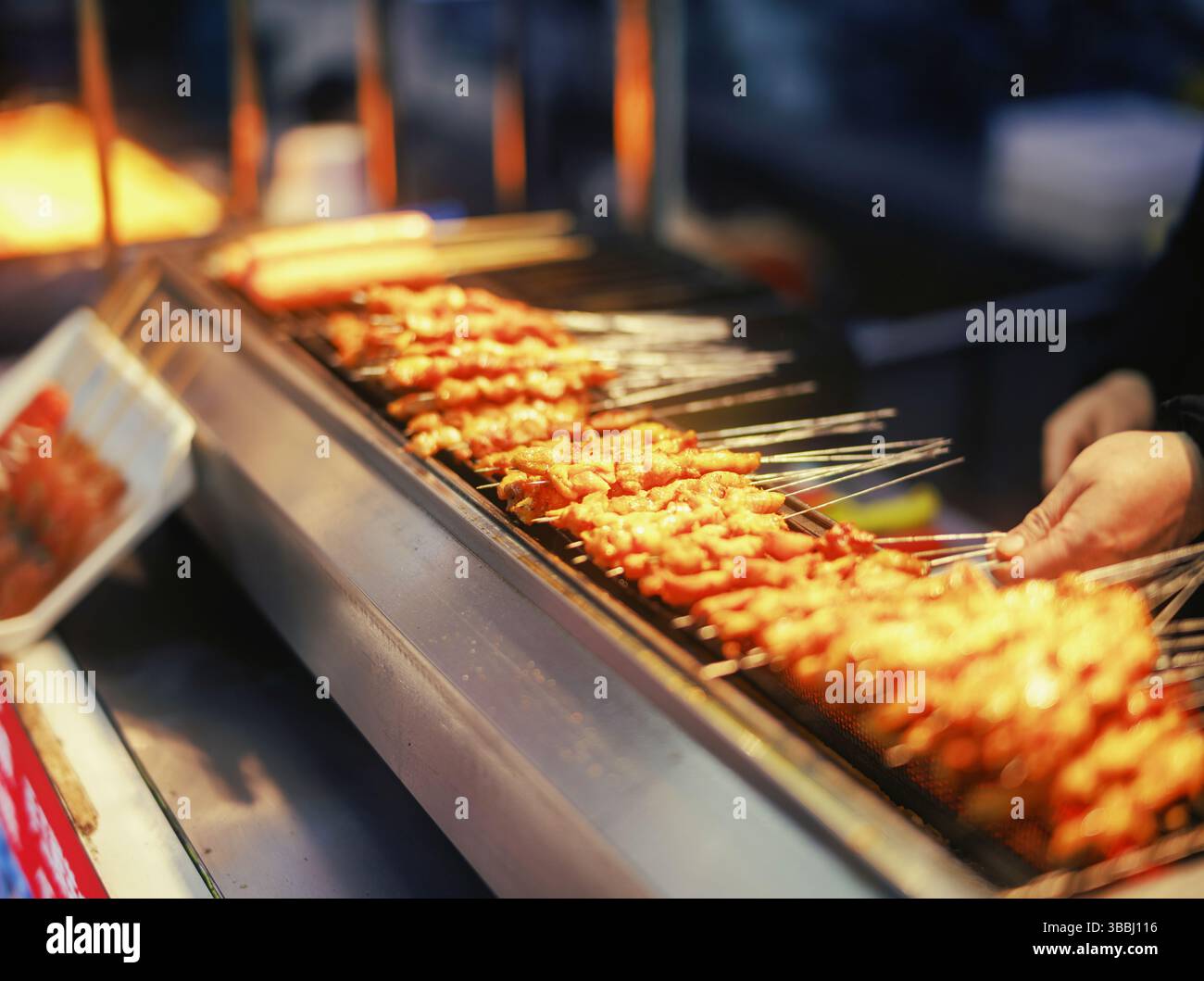 Spiedini di carne grigliati dorati arrostiti sopra la fiamma aperta in uno stand di Street Food BBQ Foto Stock