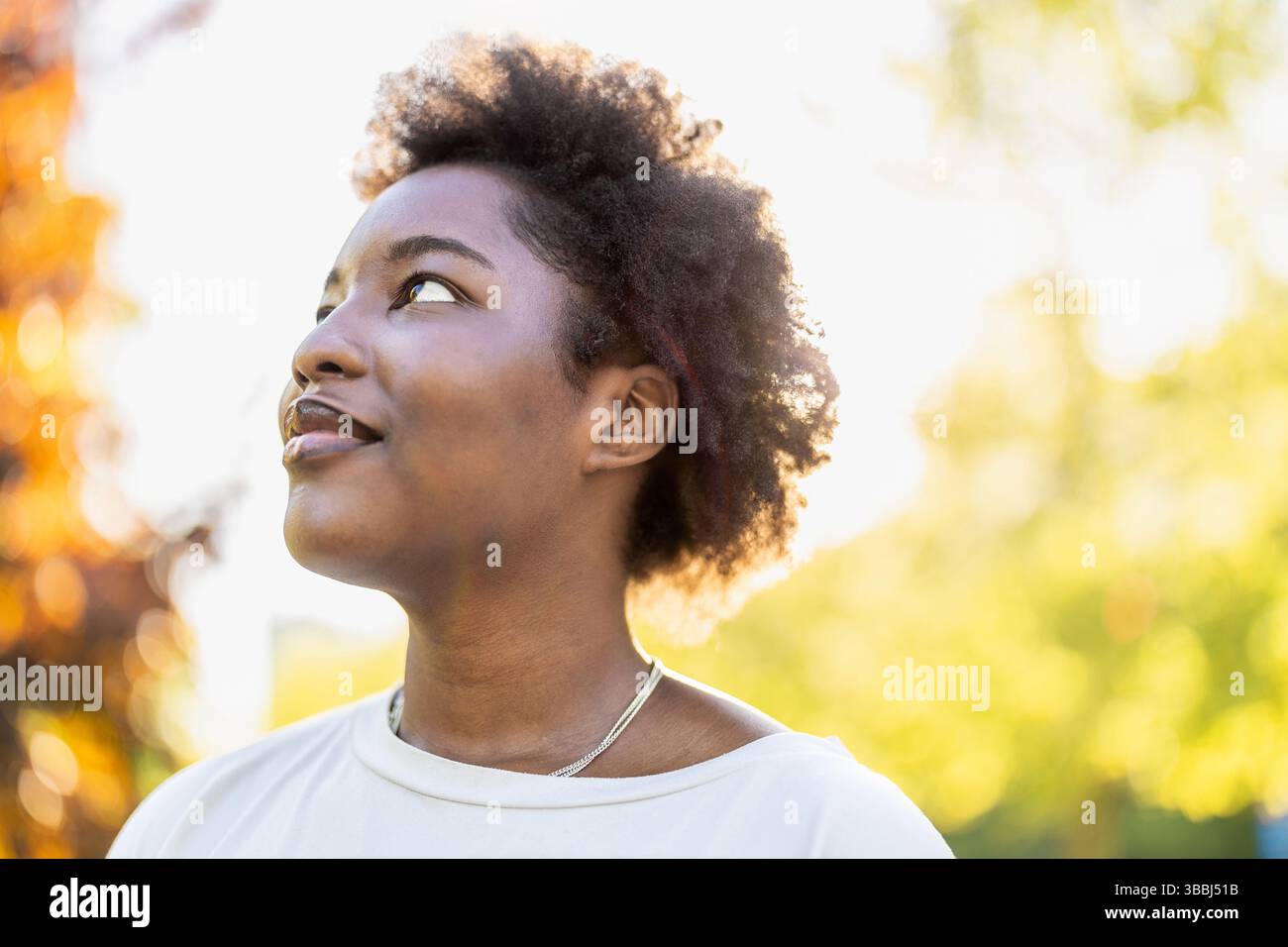Sorridente giovane donna nel parco in una giornata di sole Foto Stock