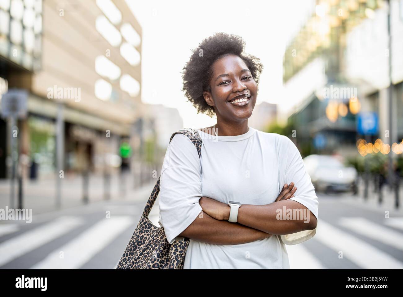 Ritratto di una giovane donna sorridente in città in una giornata di sole Foto Stock