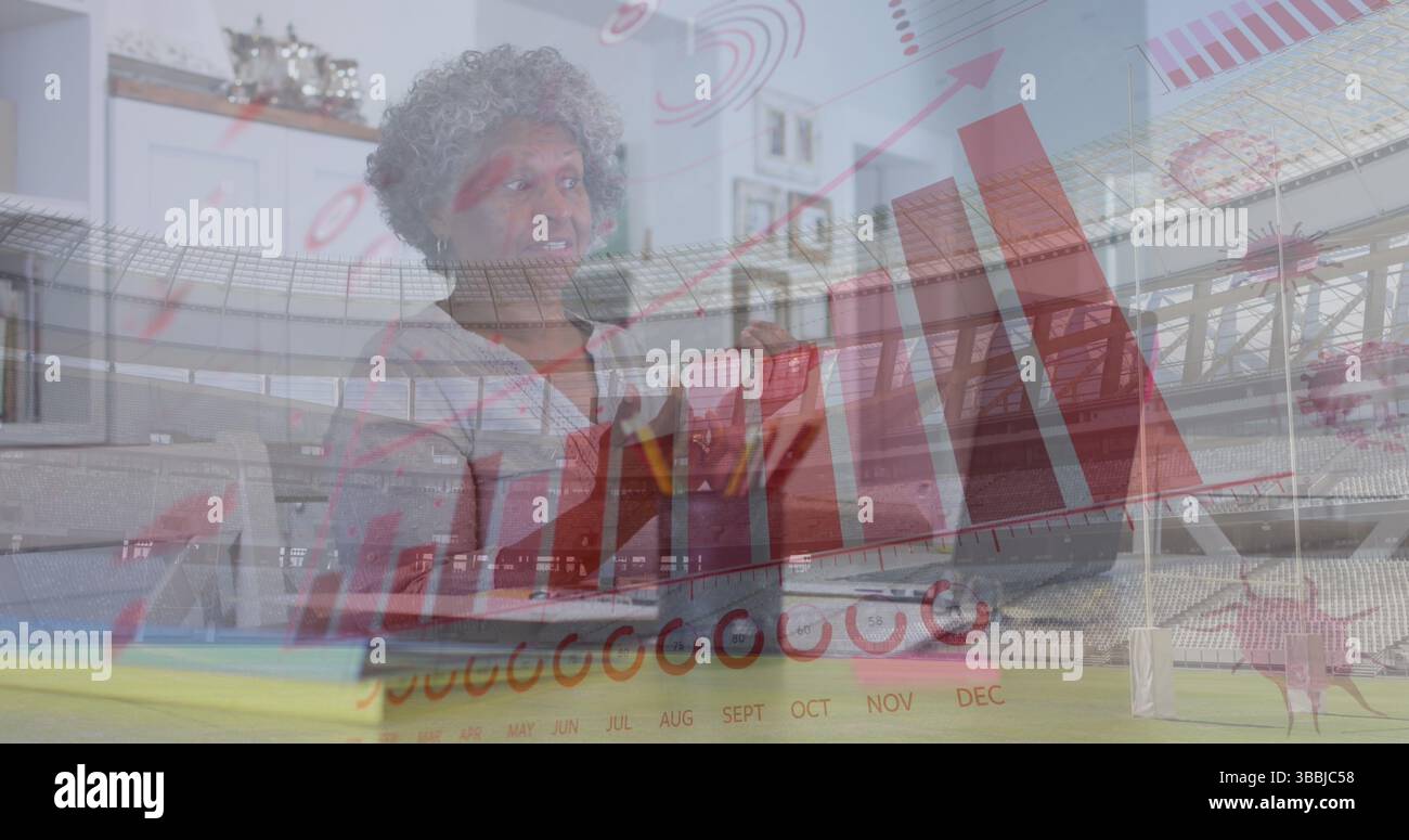 Donna afro-americana anziana che presenta i dati in un ufficio domestico, con laptop e tazza da caffè Foto Stock