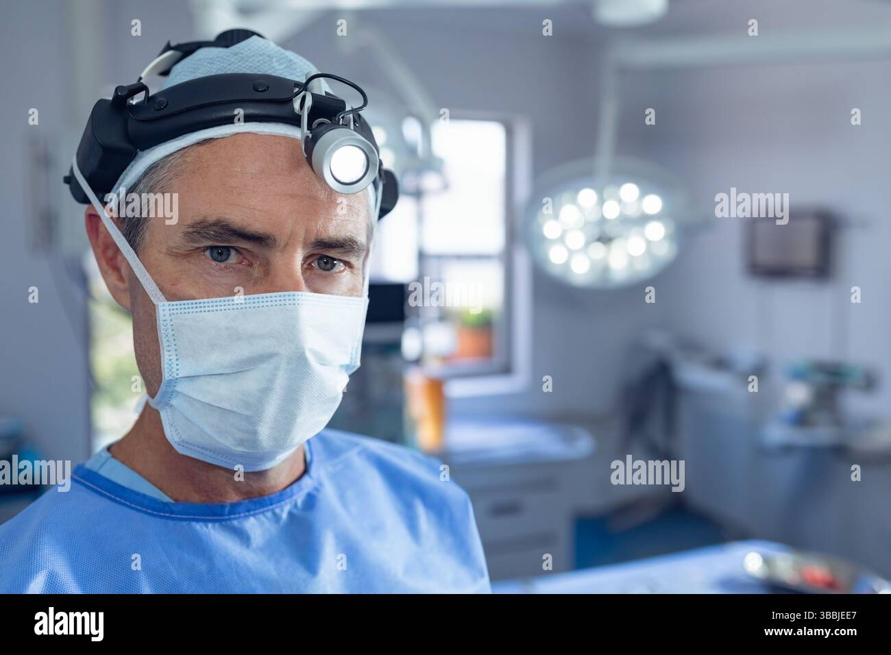 Vassoi e apparecchiature medicali poggiati sotto la lampada chirurgica sopraelevata durante l'intervento chirurgico in sala operatoria Foto Stock