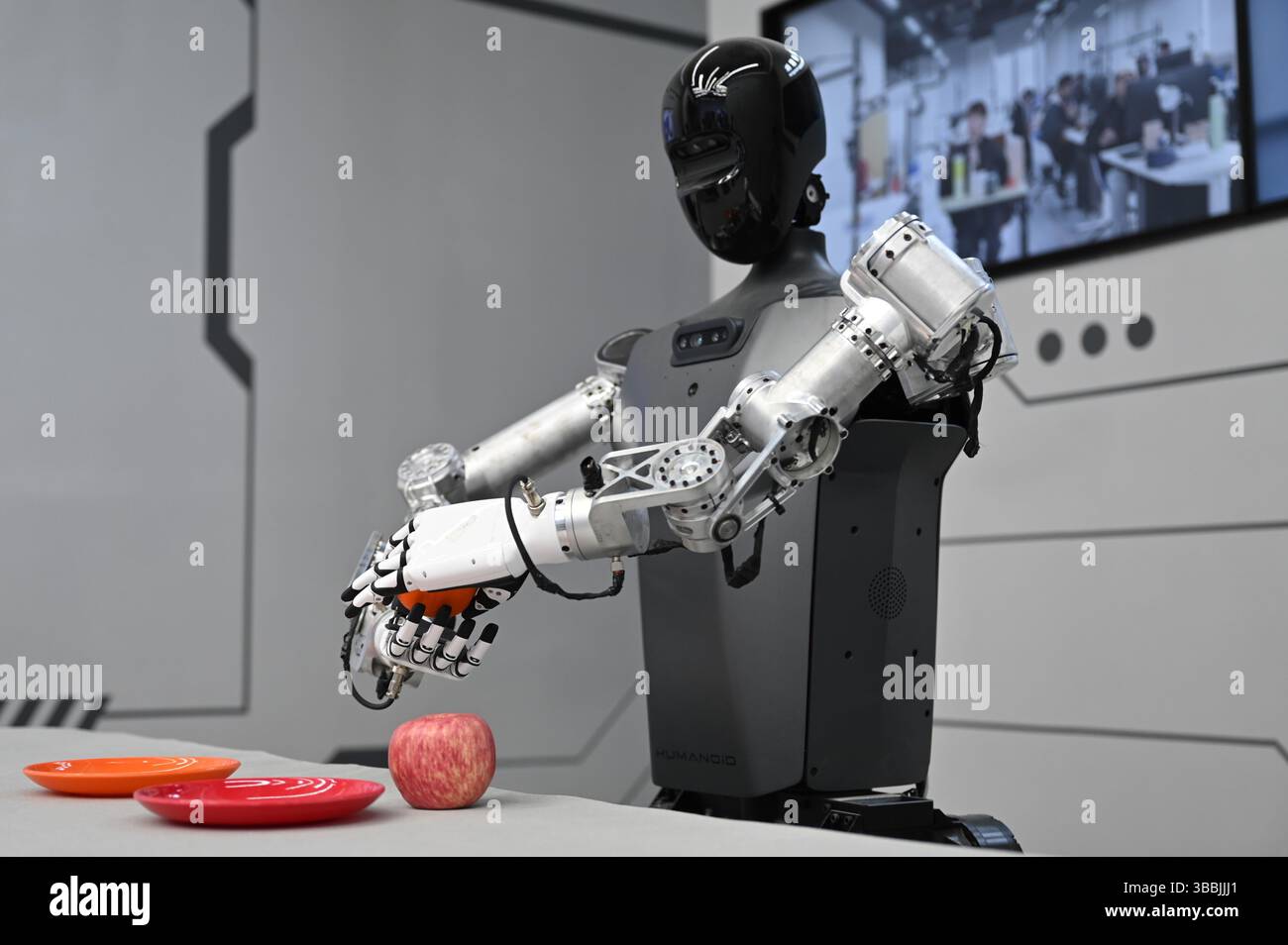 Pechino, Cina. 16 maggio 2025. Un robot "Tiangong" tiene in mano un arancione. La Cina vuole promuovere lo sviluppo di robot umanoidi. Credito: Johannes Neudecker/dpa/Alamy Live News Foto Stock