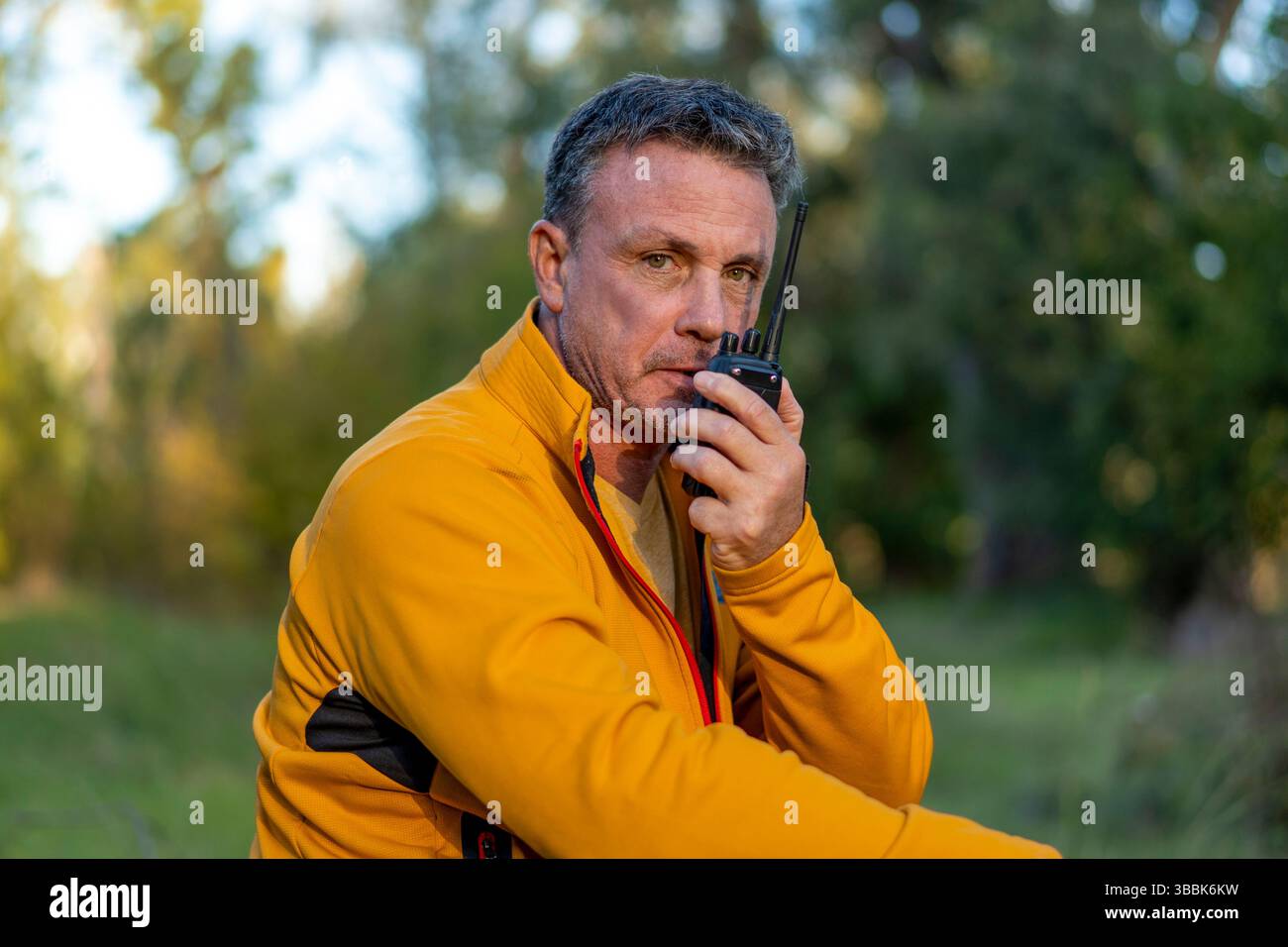 Escursionista maschile che utilizza dispositivi di comunicazione nella natura selvaggia Foto Stock