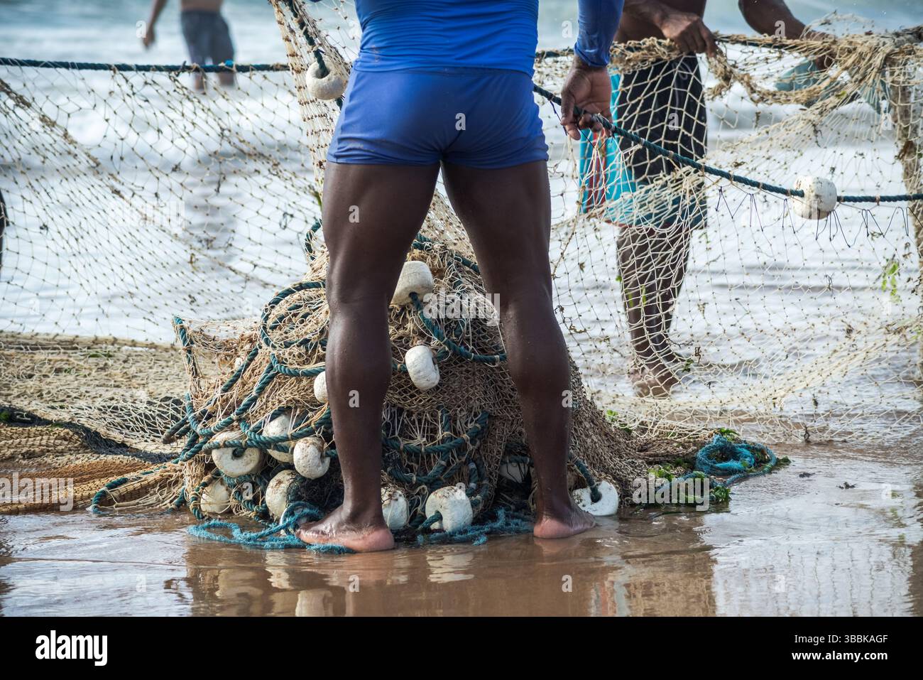 Mezzo corpo di pescatori non identificati che raccolgono la rete da pesca dopo la cattura del pesce. Pesce, pesca come hobby. Brasile Foto Stock