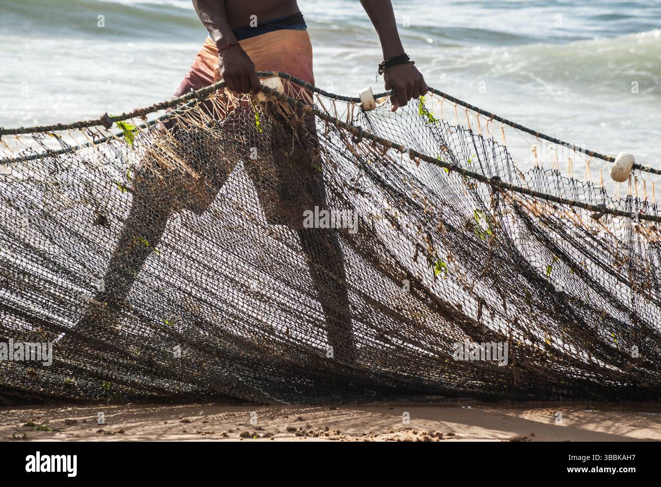 Mezzo corpo di un pescatore non identificato che tira una rete da pesca. specialità di pesce, hobby. Brasile Foto Stock