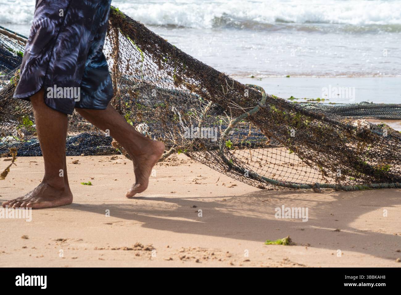 Mezzo corpo di pescatori non identificati che raccolgono la rete da pesca dopo la cattura del pesce. Pesce, pesca come hobby. Brasile Foto Stock