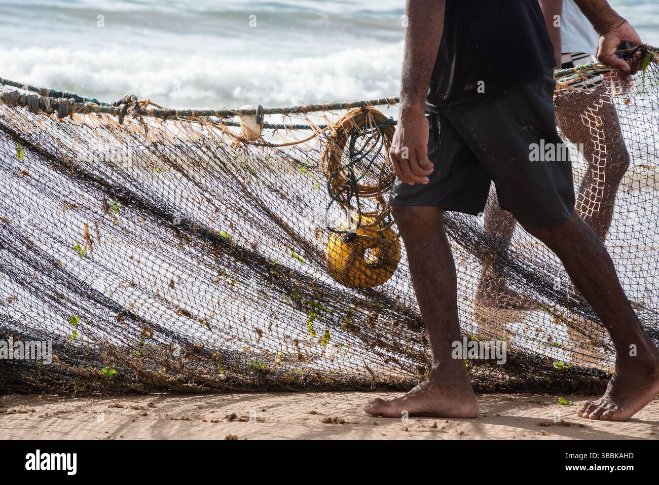 Mezzo corpo di pescatori non identificati che raccolgono la rete da pesca dopo la cattura del pesce. Pesce, pesca come hobby. Brasile Foto Stock