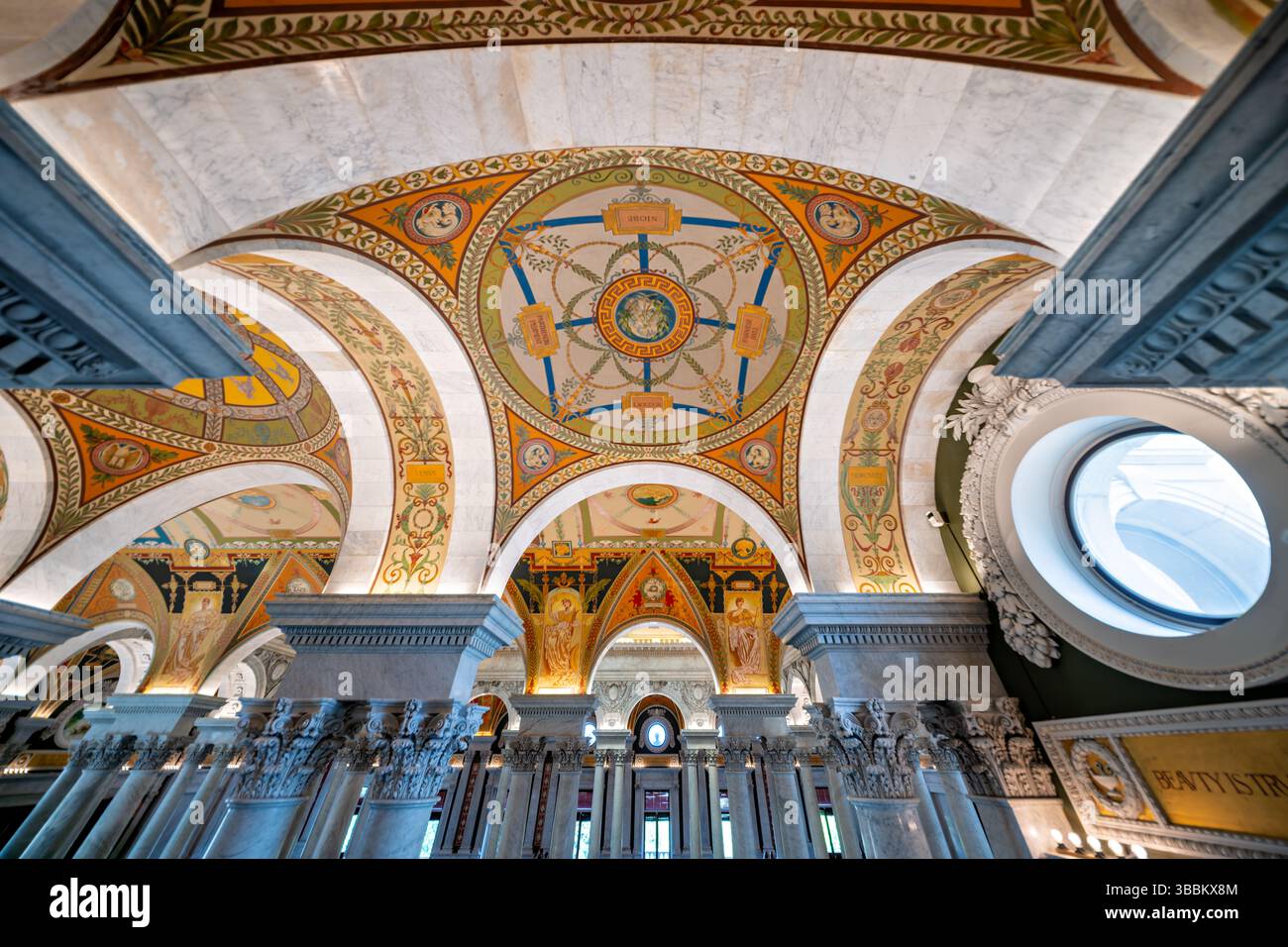 WASHINGTON DC - la grande sala decorata con decorazioni del Thomas Jefferson Building presso la Library of Congress mette in mostra il massimo dell'architettura Beaux-Arts americana. Completata nel 1897, la sala presenta una grande scalinata fiancheggiata da statue in bronzo, colonne in marmo, mosaici elaborati e un soffitto a cassettoni adornato con lucernari placcati in rame e dipinti allegorici. Lo spazio è impreziosito da foglie d'oro, intricate incisioni e murales di importanti artisti americani tra cui Edwin Blashfield, Elihu Vedder e John White Alexander, tutti celebranti temi della conoscenza, della letteratura e del ronzio Foto Stock