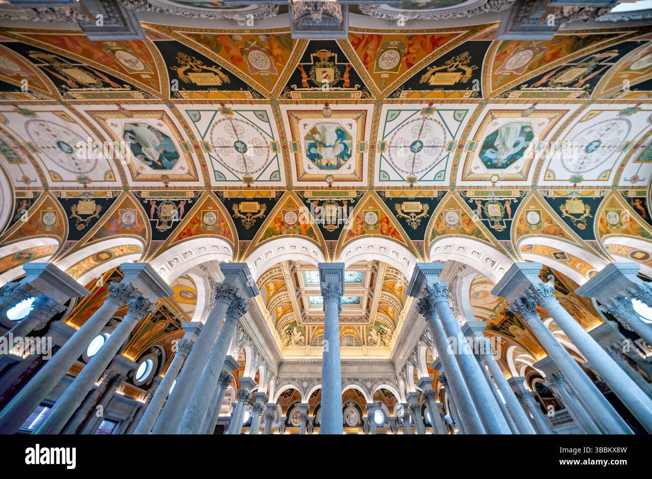 WASHINGTON DC - la grande sala decorata con decorazioni del Thomas Jefferson Building presso la Library of Congress mette in mostra il massimo dell'architettura Beaux-Arts americana. Completata nel 1897, la sala presenta una grande scalinata fiancheggiata da statue in bronzo, colonne in marmo, mosaici elaborati e un soffitto a cassettoni adornato con lucernari placcati in rame e dipinti allegorici. Lo spazio è impreziosito da foglie d'oro, intricate incisioni e murales di importanti artisti americani tra cui Edwin Blashfield, Elihu Vedder e John White Alexander, tutti celebranti temi della conoscenza, della letteratura e del ronzio Foto Stock