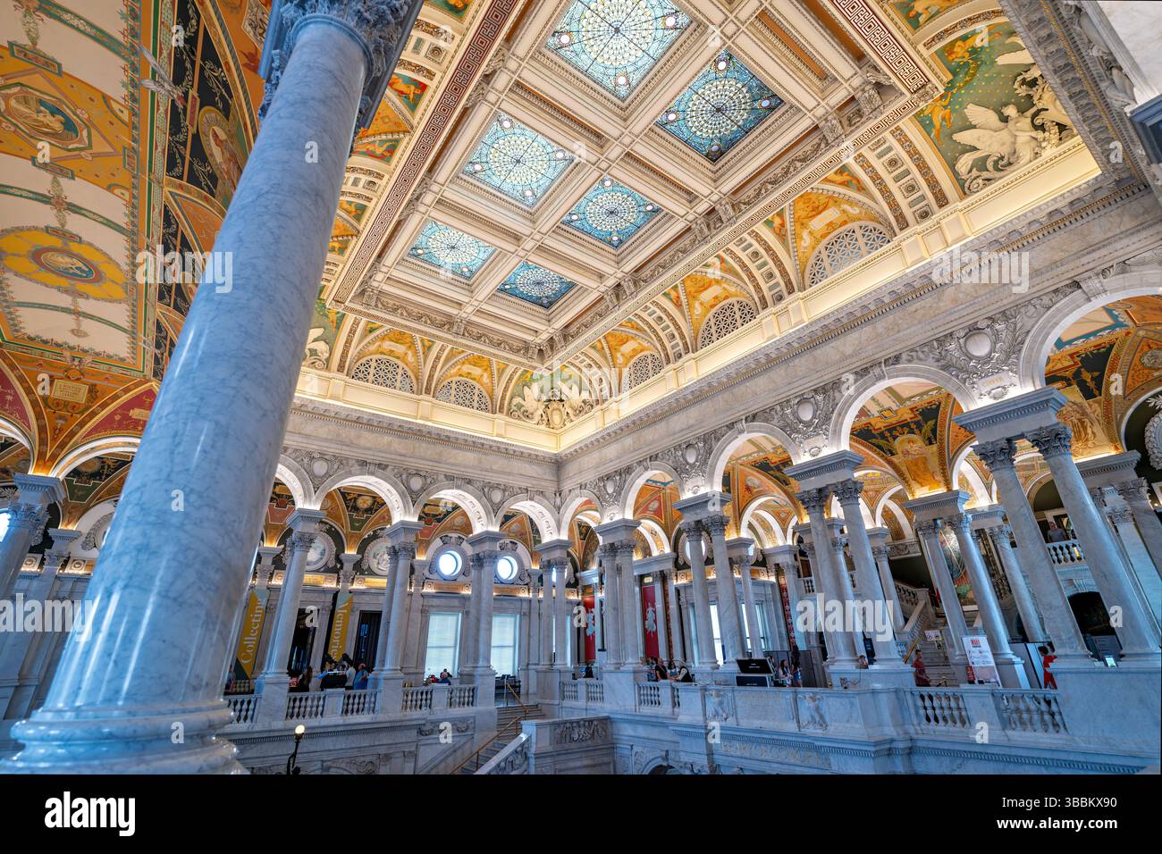 WASHINGTON DC - la grande sala decorata con decorazioni del Thomas Jefferson Building presso la Library of Congress mette in mostra il massimo dell'architettura Beaux-Arts americana. Completata nel 1897, la sala presenta una grande scalinata fiancheggiata da statue in bronzo, colonne in marmo, mosaici elaborati e un soffitto a cassettoni adornato con lucernari placcati in rame e dipinti allegorici. Lo spazio è impreziosito da foglie d'oro, intricate incisioni e murales di importanti artisti americani tra cui Edwin Blashfield, Elihu Vedder e John White Alexander, tutti celebranti temi della conoscenza, della letteratura e del ronzio Foto Stock