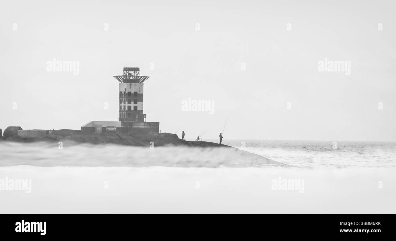 Faro della costa olandese: Uno studio bianco e nero del faro di Zandvoort nelle nebbie Foto Stock
