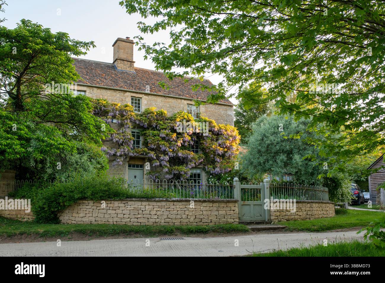 Grande casa in pietra in primavera nel villaggio di Dean, Cotswolds, Oxfordshire, Inghilterra Foto Stock