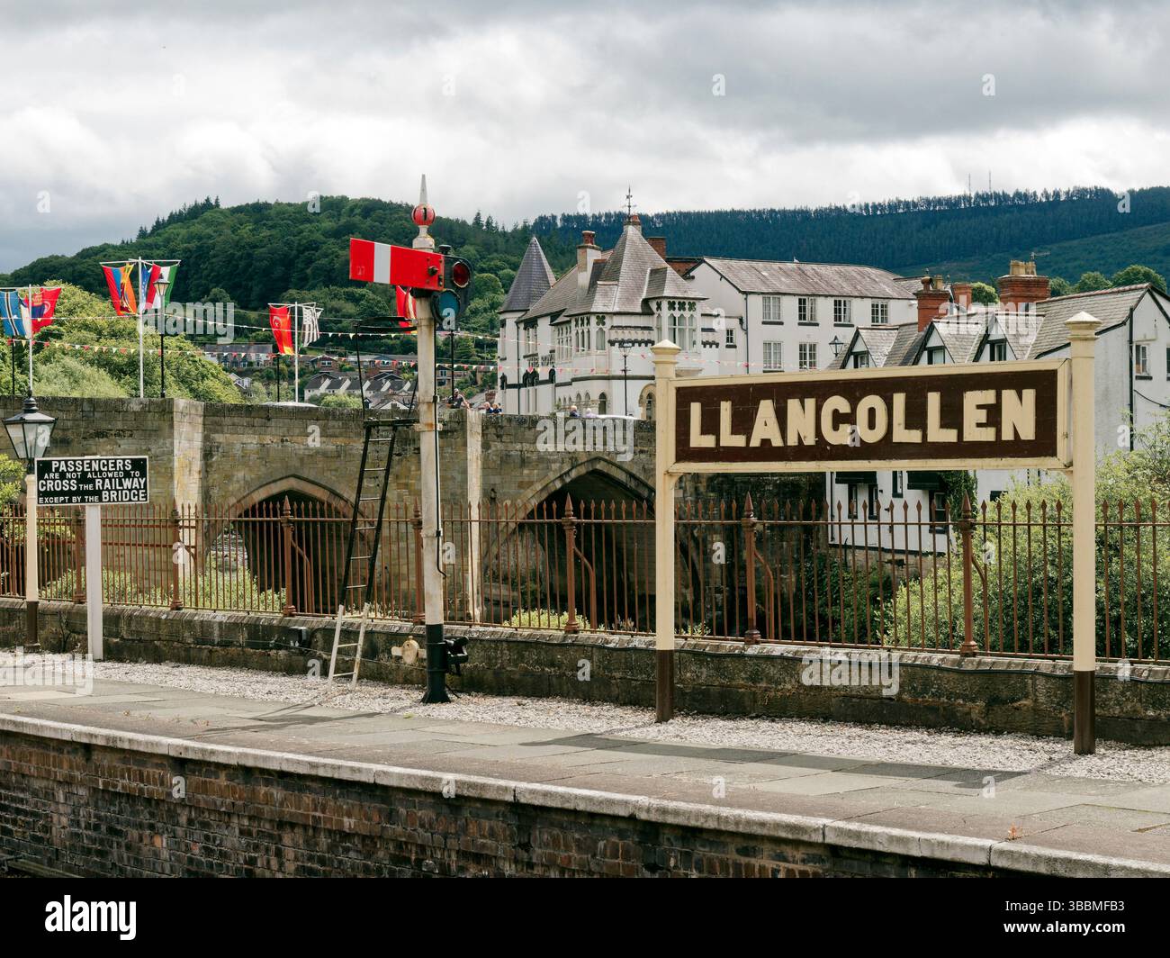 Stazione ferroviaria di Llangollen, stazione principale della Llangollen Railway Heritage line con il nome della stazione e il ponte sul fiume Dee Foto Stock