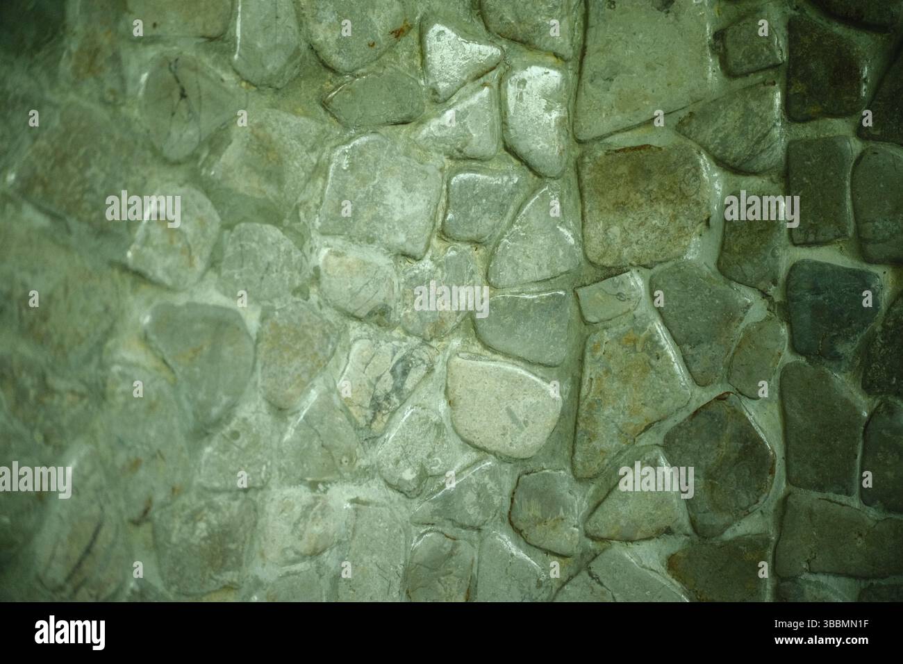 Un'immagine ravvicinata di un muro di pietra strutturata fatto di rocce di forma irregolare Foto Stock