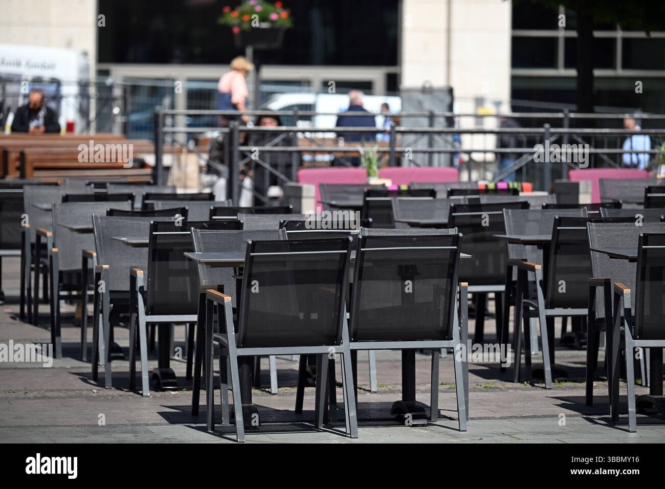 Essen, Germania. 16 maggio 2025. Tavoli e panchine attendono gli ospiti al Kennedyplatz. (A dpa: Birrerie all'aperto e terrazze caffè - più spazio per la gastronomia all'aperto dal 17.05.20259 crediti: Federico Gambarini/dpa/Alamy Live News Foto Stock