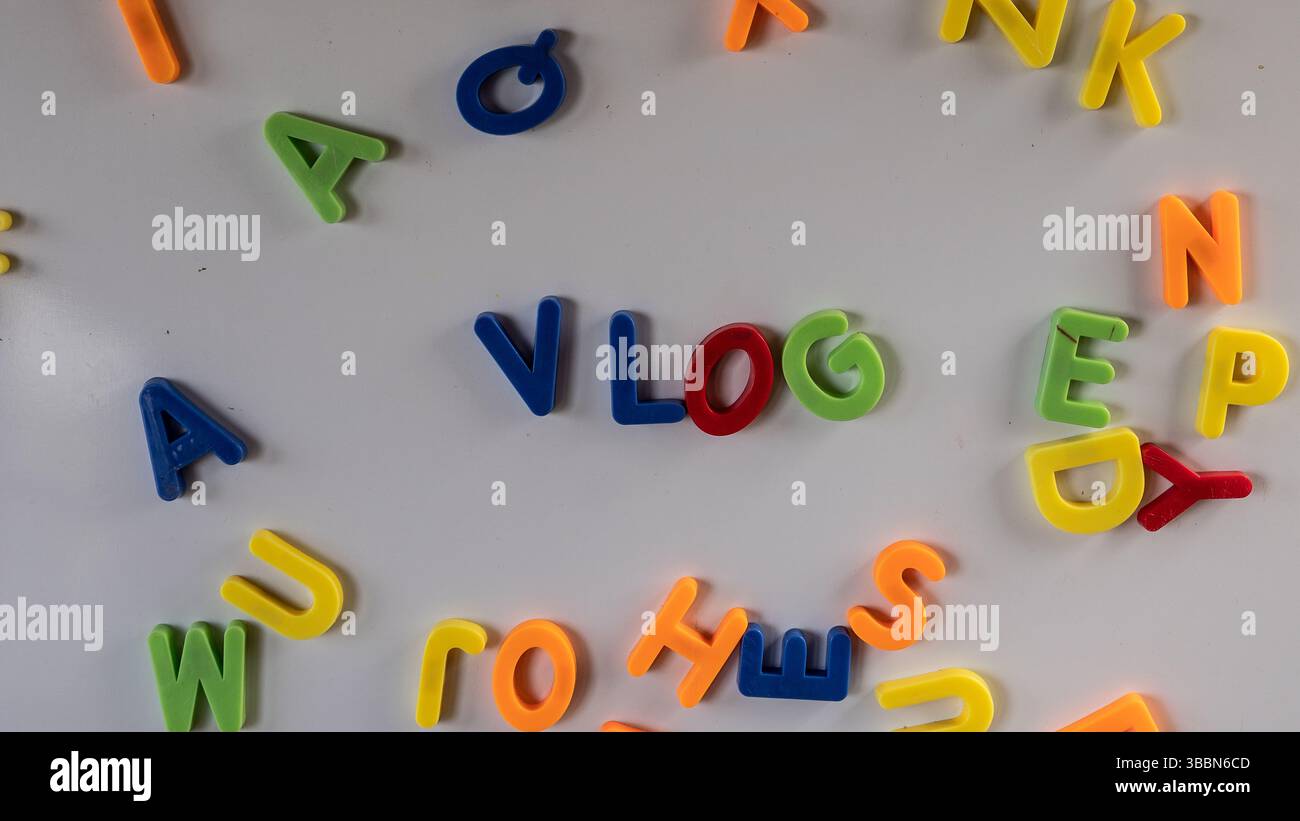 Lettere magnetiche colorate "vlog" su una lavagna in legno in aula o in sala giochi. Foto Stock